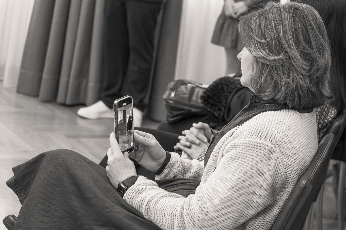 Gast fotografiert einen Moment mit dem eigenen Handy während einer dokumentarischen Hochzeit